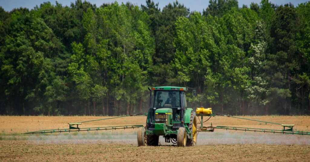 A tractor is spraying in fields.